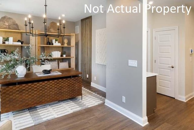 unfurnished office featuring dark hardwood / wood-style flooring and an inviting chandelier