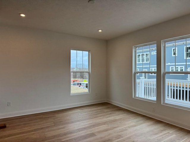 spare room featuring light hardwood / wood-style flooring and a healthy amount of sunlight