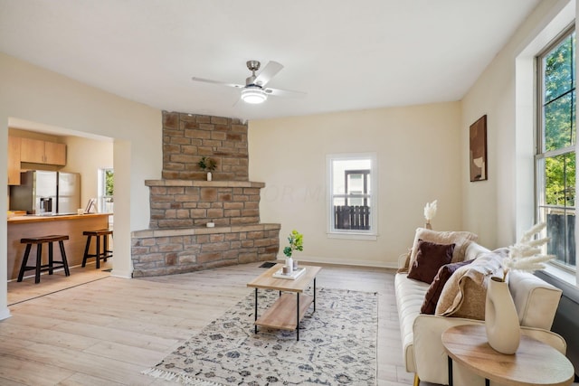 living room with ceiling fan, light hardwood / wood-style flooring, and a healthy amount of sunlight