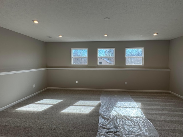 carpeted spare room with a textured ceiling, recessed lighting, and baseboards