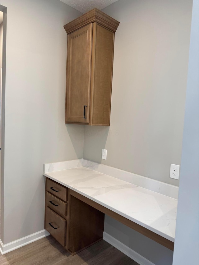 interior space featuring baseboards, wood finished floors, and vanity