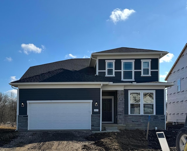 view of front of home featuring a garage, stone siding, and a shingled roof