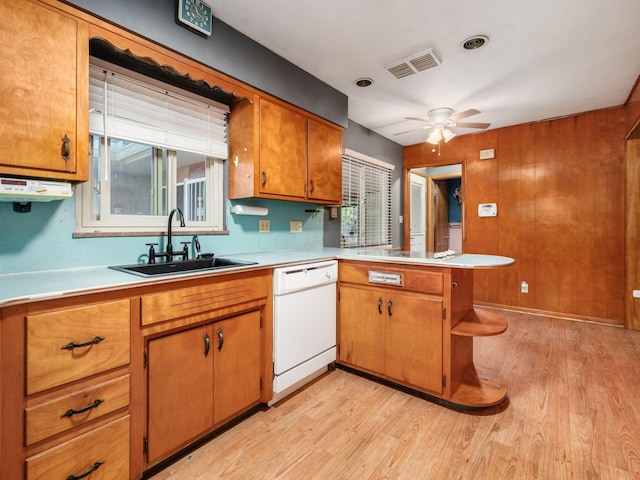 kitchen featuring kitchen peninsula, light wood-type flooring, ceiling fan, sink, and dishwasher