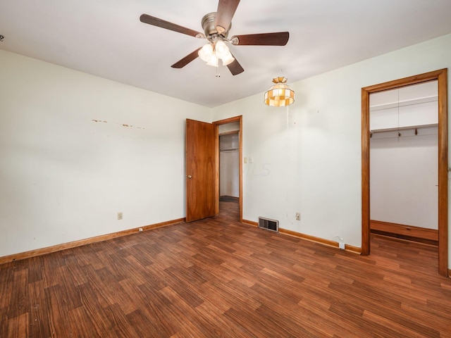 unfurnished bedroom featuring dark hardwood / wood-style floors, ceiling fan, and a closet