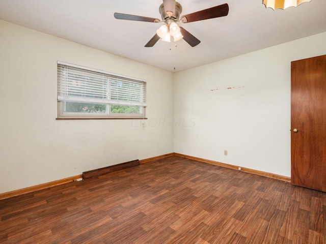 empty room with ceiling fan and dark wood-type flooring