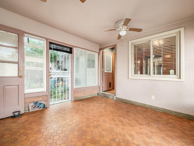 interior space with ceiling fan and crown molding