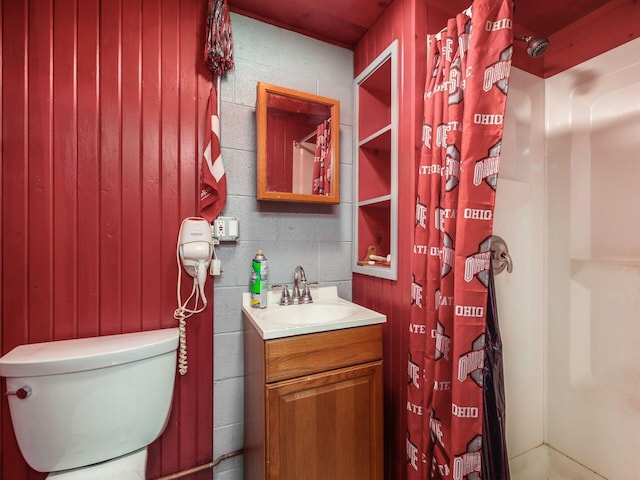 bathroom with wooden walls, vanity, a shower with shower curtain, and toilet