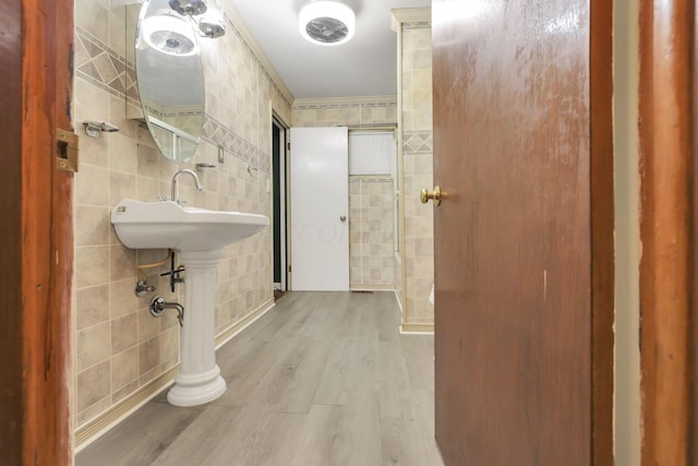 bathroom featuring hardwood / wood-style floors, sink, and tile walls