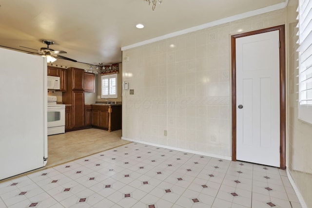 kitchen featuring ceiling fan, sink, tile walls, and white appliances