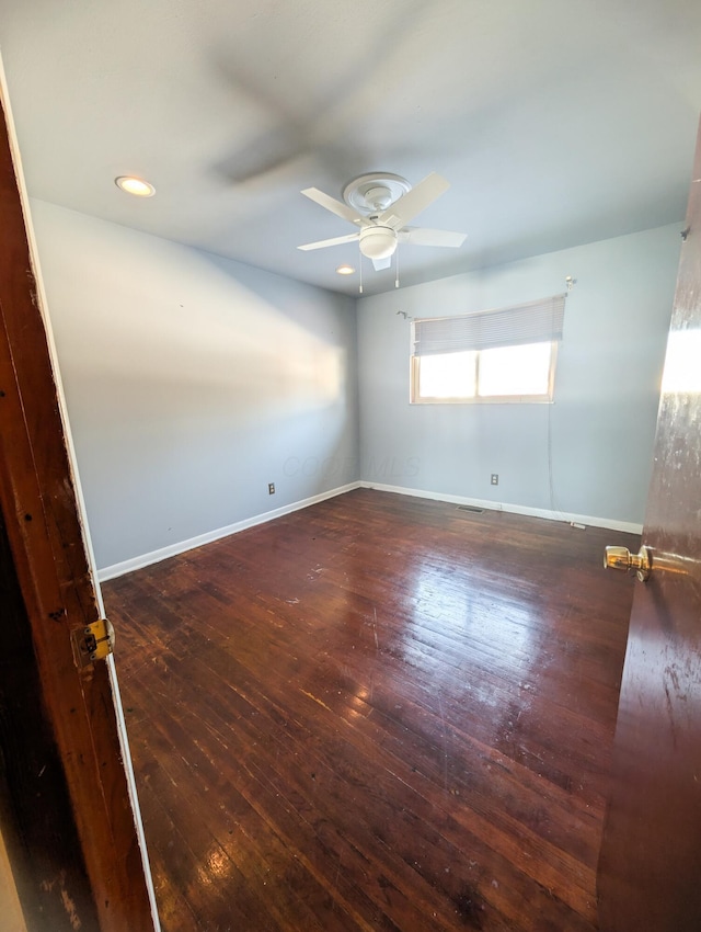 empty room with dark hardwood / wood-style floors and ceiling fan