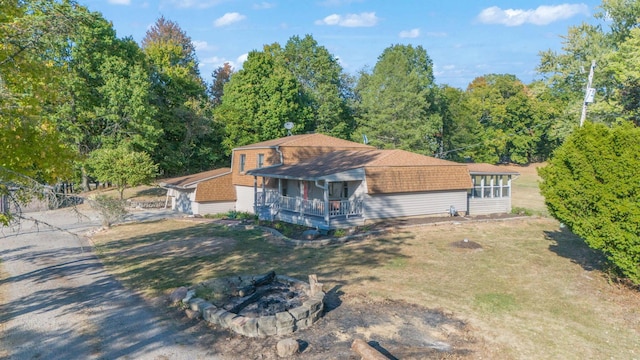 rear view of house with covered porch and a fire pit