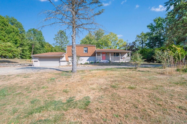 view of front of house featuring a front yard, a porch, and a garage