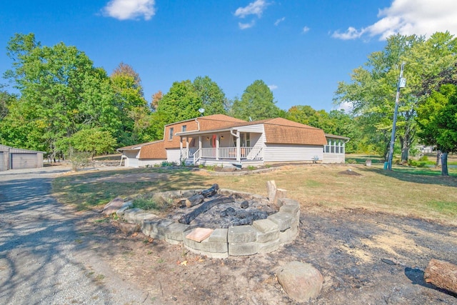 back of house with a porch and an outdoor fire pit