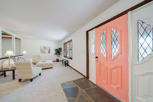 carpeted entryway featuring lofted ceiling