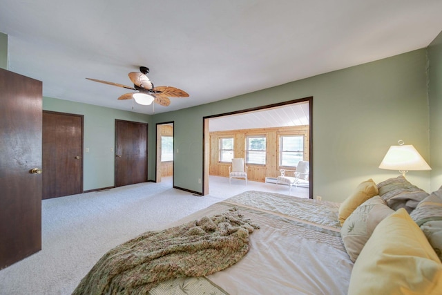 carpeted bedroom with multiple closets and ceiling fan