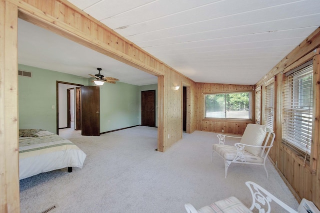 carpeted bedroom featuring baseboard heating, ceiling fan, wooden walls, and lofted ceiling