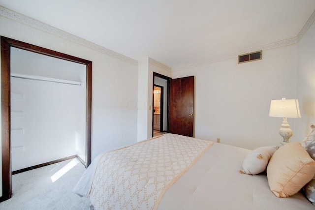 bedroom with a closet, carpet floors, and ornamental molding