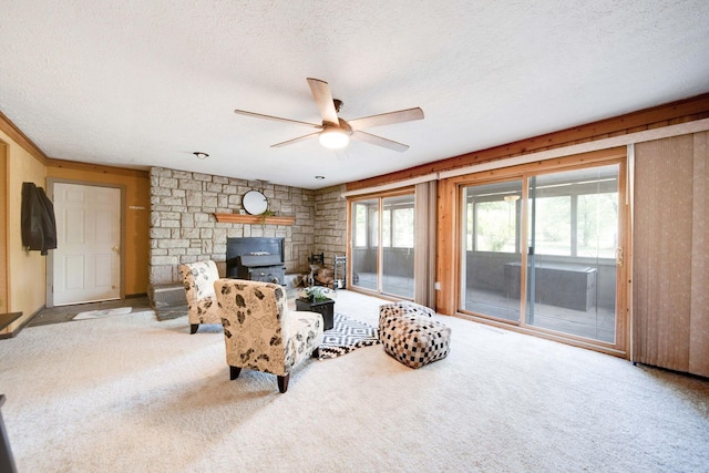 living room with ceiling fan, a wood stove, and a textured ceiling