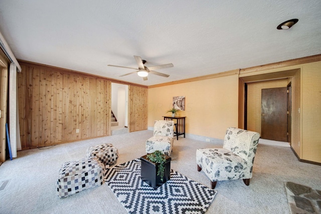 living area featuring light colored carpet, ornamental molding, and a textured ceiling