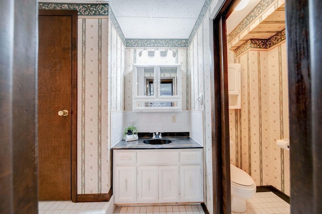 bathroom with tile patterned flooring, vanity, and toilet