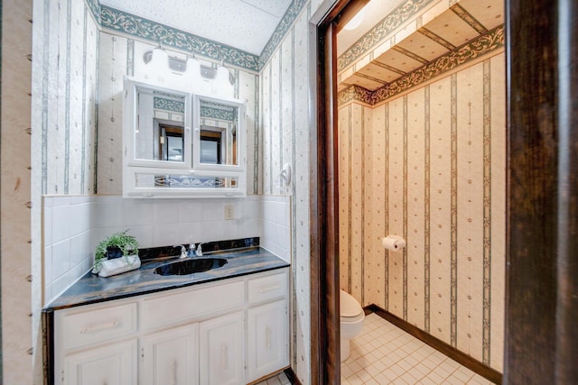 bathroom featuring tile patterned flooring, vanity, and toilet