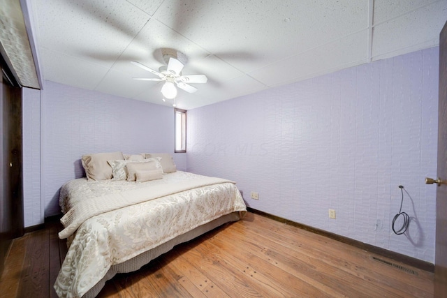 bedroom with ceiling fan and wood-type flooring