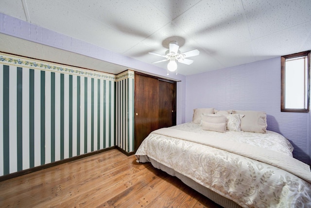 bedroom with ceiling fan and wood-type flooring