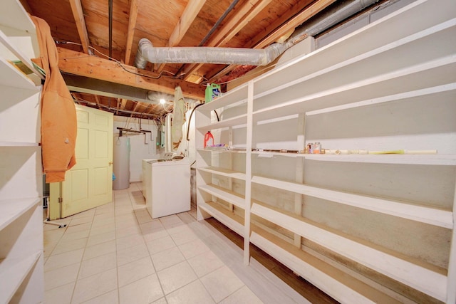 basement with light tile patterned floors, washer and dryer, and gas water heater