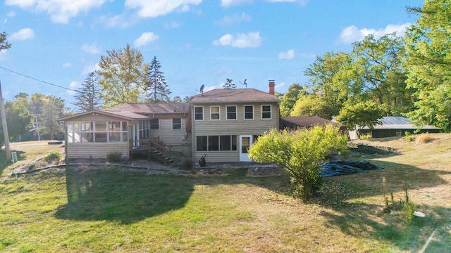 back of house with a sunroom and a lawn