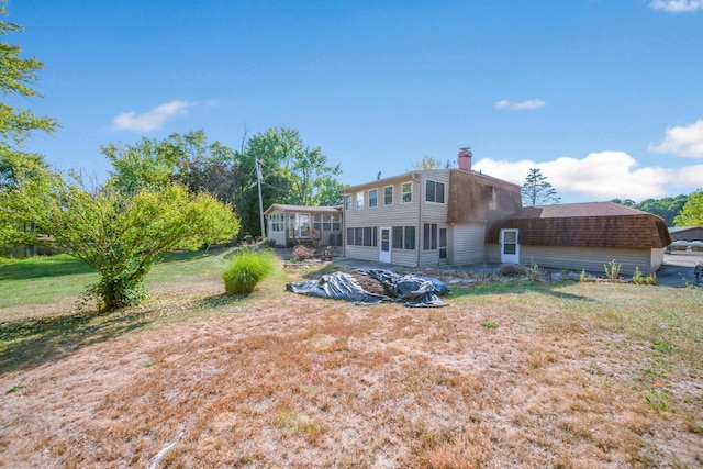 back of house featuring a sunroom and a yard