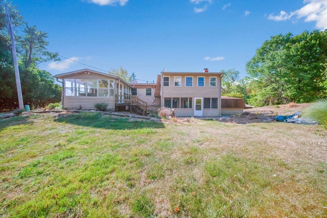 back of property with a yard and a sunroom