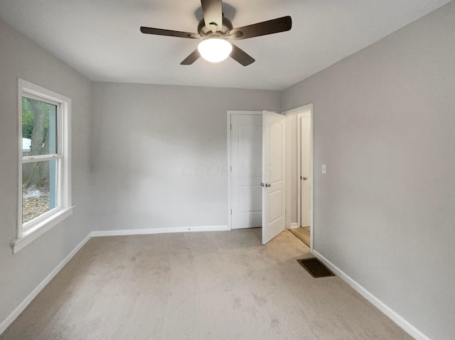 carpeted empty room featuring ceiling fan