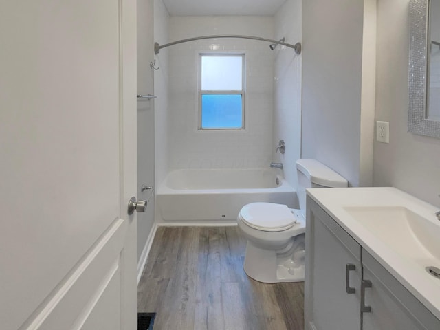 full bathroom featuring hardwood / wood-style flooring, vanity, toilet, and tiled shower / bath