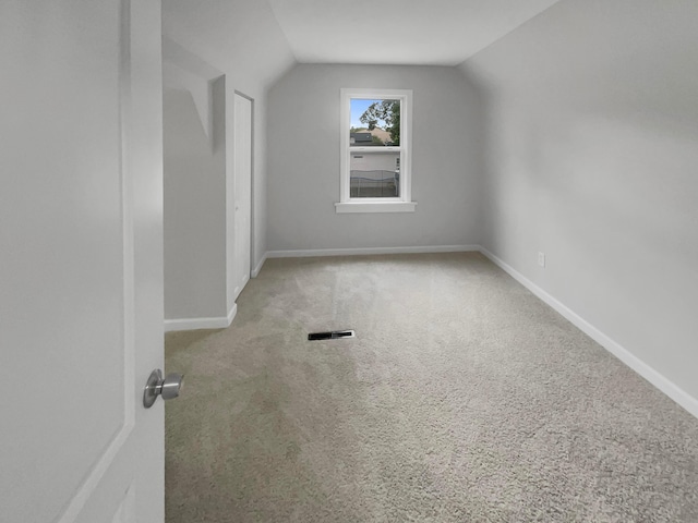 additional living space with light colored carpet and lofted ceiling