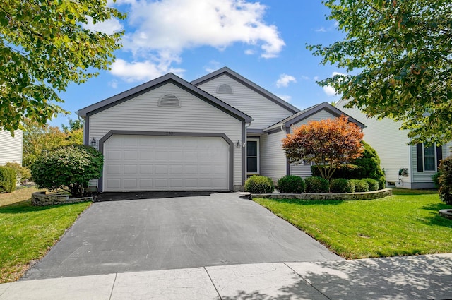 view of front of property featuring a front yard and a garage