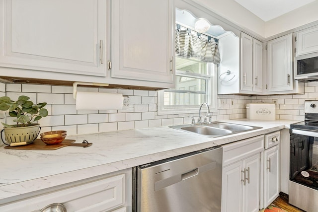 kitchen featuring appliances with stainless steel finishes, sink, and white cabinets