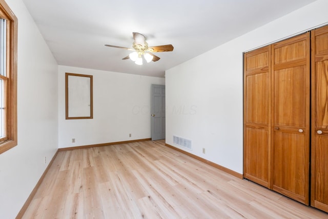 unfurnished bedroom with ceiling fan, a closet, and light hardwood / wood-style flooring