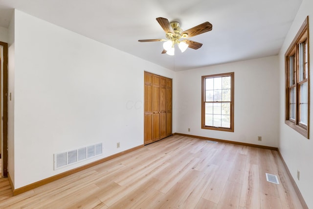 unfurnished bedroom featuring a closet, ceiling fan, and light wood-type flooring