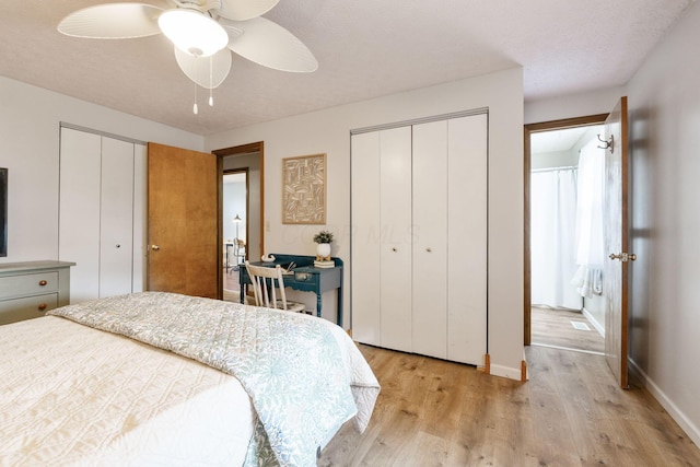 bedroom with multiple closets, light hardwood / wood-style flooring, and ceiling fan