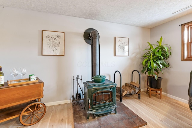 details featuring hardwood / wood-style floors, a textured ceiling, and a wood stove