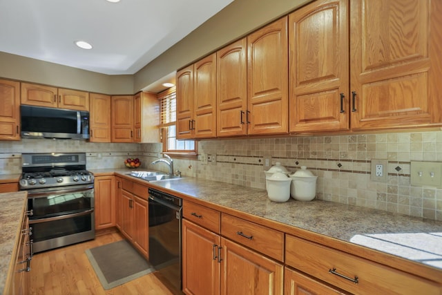 kitchen featuring light hardwood / wood-style floors, sink, appliances with stainless steel finishes, and tasteful backsplash