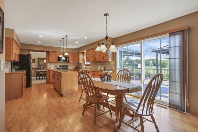 dining space with a chandelier and light hardwood / wood-style floors