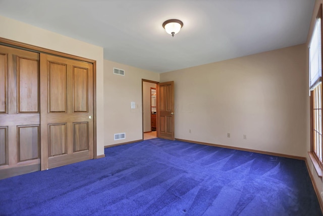 unfurnished bedroom featuring carpet and a closet