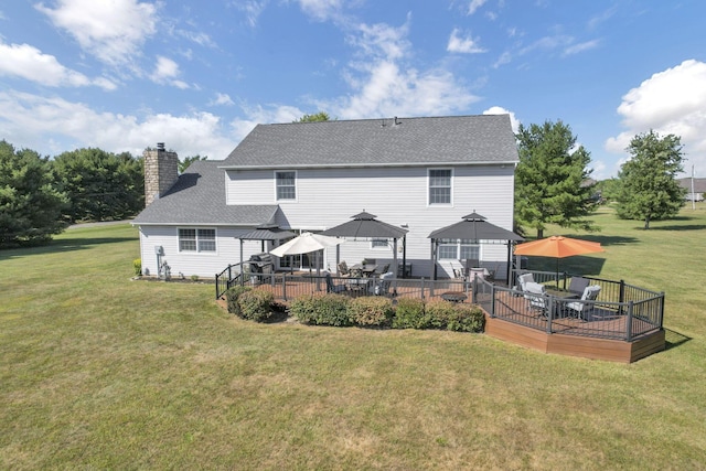 rear view of property with a gazebo, a wooden deck, and a yard