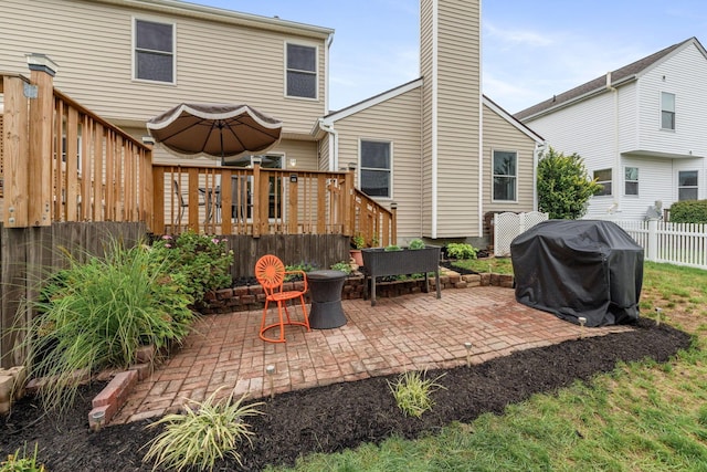 rear view of property with a wooden deck and a patio