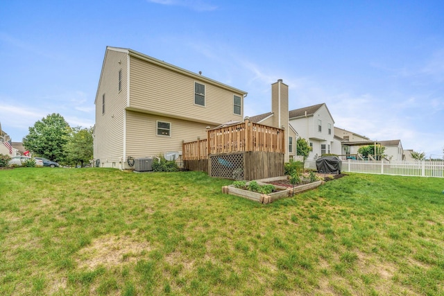 back of house with a wooden deck, a lawn, and cooling unit