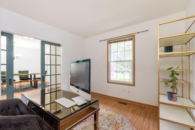 home office featuring french doors and light wood-type flooring