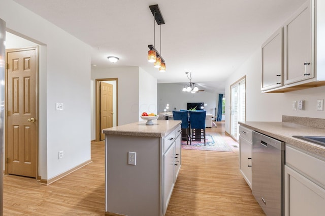 kitchen featuring light hardwood / wood-style flooring, hanging light fixtures, stainless steel dishwasher, a kitchen island, and white cabinets