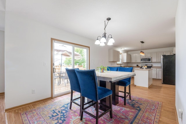 dining area with a chandelier and light hardwood / wood-style flooring