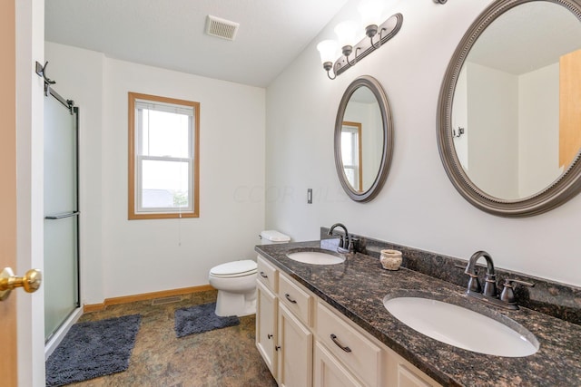 bathroom featuring vanity, toilet, a textured ceiling, and a shower with shower door